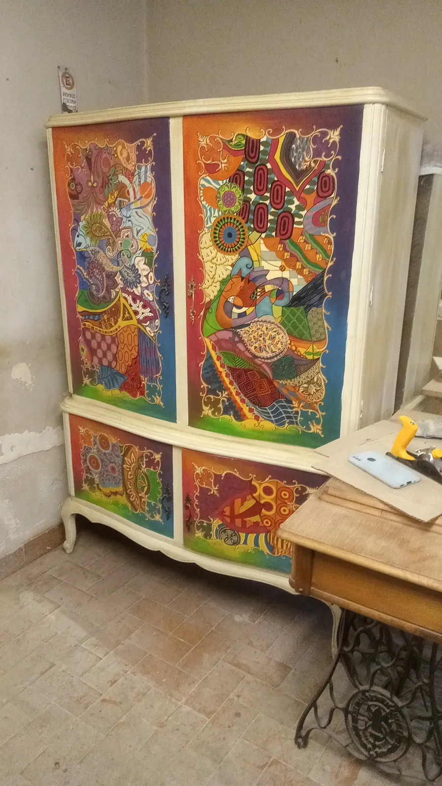 Aparador antes de la restauración, con pintura decorativa desgastada.